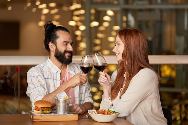 casal a comer e a beber vinho vermelho num restaurante