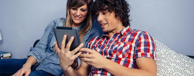 Foto casal a ver vídeo num tablet digital em casa