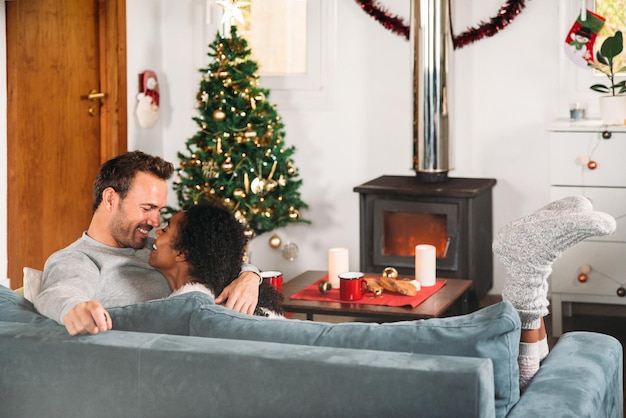 Casal abraçado no sofá durante o natal