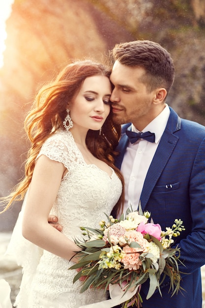 Casal abraçando ao pôr do sol, casal de amantes beijando no pôr do sol. Cerimônia de casamento ao ar livre