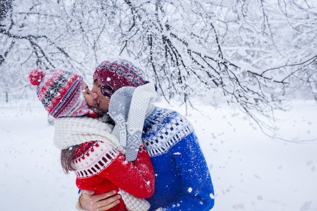 Casal abraços e beijos na floresta de inverno