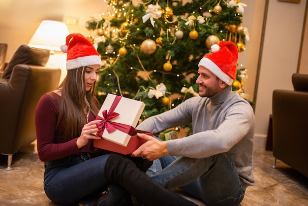 Casal abrindo um presente de natal