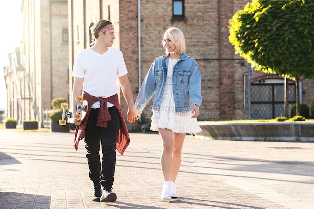 Casal adolescente com longboard durante encontro na cidade