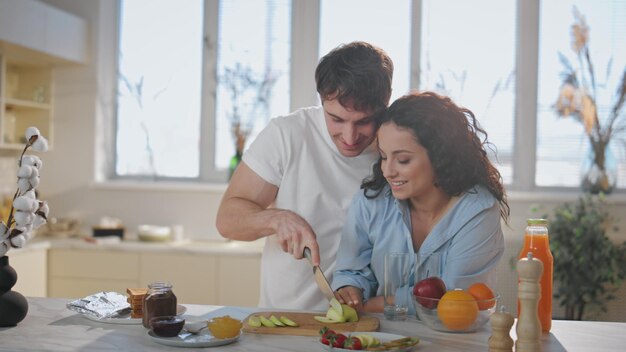 Casal adorável preparando uma refeição para um pequeno-almoço saudável em uma cozinha moderna de perto