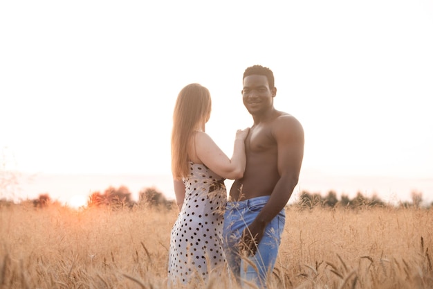 Casal adulto jovem de raça mista no campo de trigo