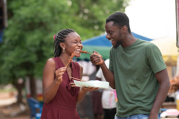 Foto casal africano comendo comida de rua