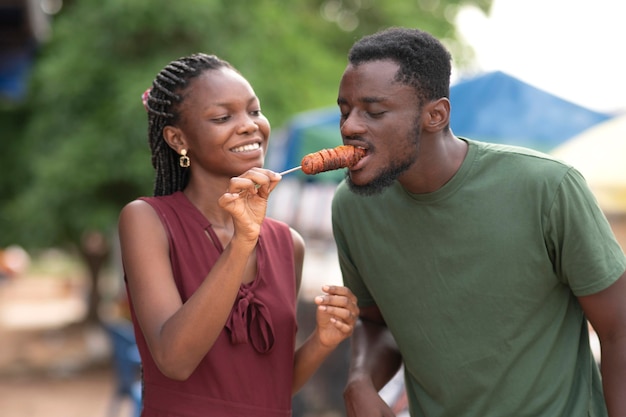 Foto casal africano comendo comida de rua