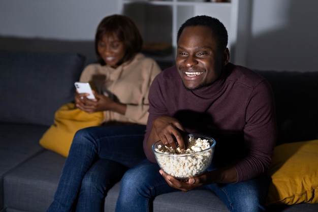 Foto casal afro-americano assistindo serviço de streaming em casa