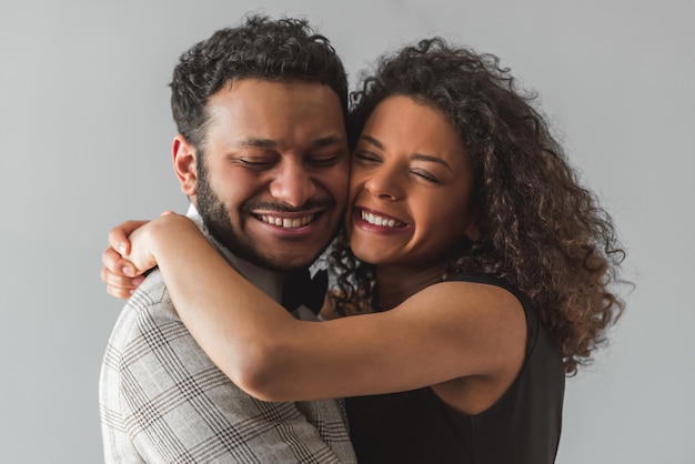 Casal afro-americano com roupa formal está abraçando