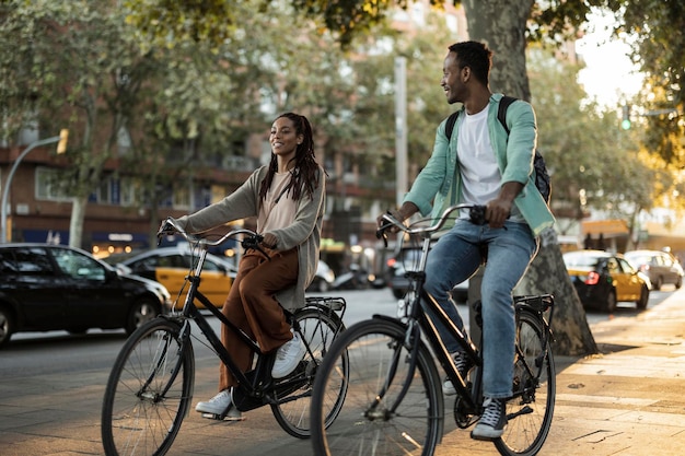 Foto casal afro-americano feliz em viagem pela cidade visitando a europa eles alugam bicicletas