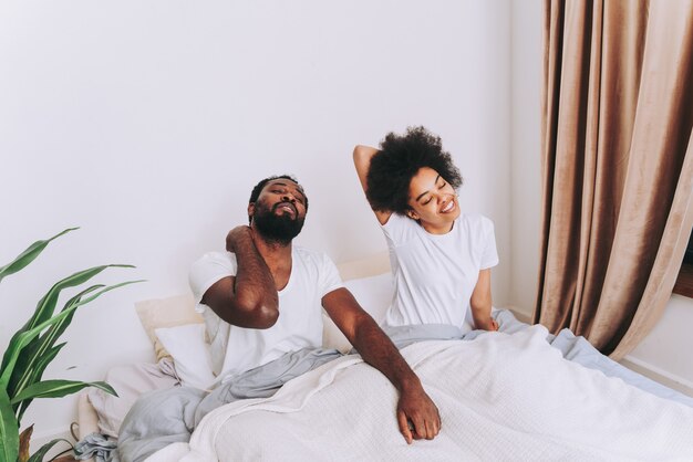 Casal afro-americano na cama - Casal de namorados lindos e alegres em casa