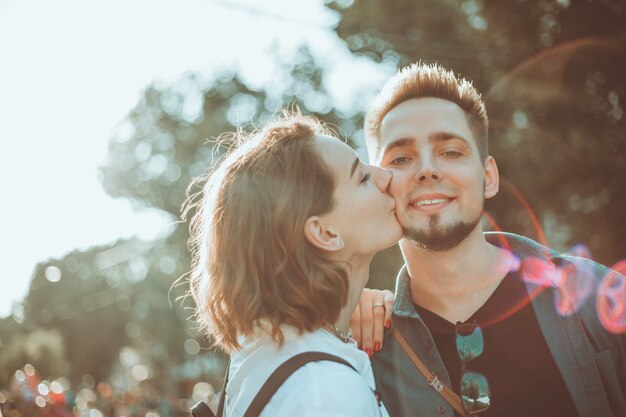 Casal alegre alegre hipster apaixonado beijando em uma rua da cidade. O conceito romântico de amantes. história de amor