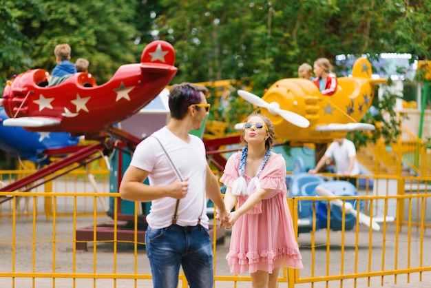 Casal alegre andando em um parque de diversões