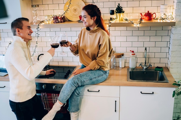 Casal alegre comemorando o natal na cozinha brilhante