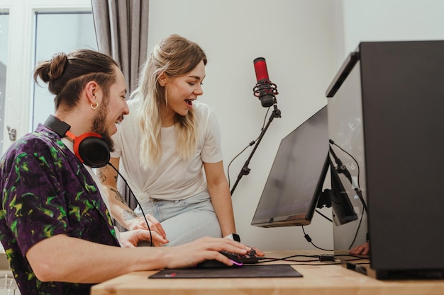 Casal alegre jogando videogame juntos no computador pessoal moderno