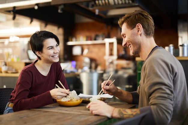 Casal alegre no restaurante de comida chinesa