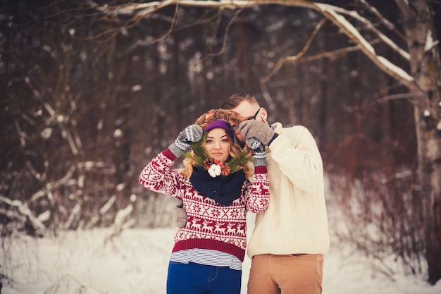 Casal alegre se divertindo na floresta de inverno