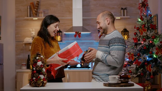 Casal alegre trocando presentes na véspera de natal