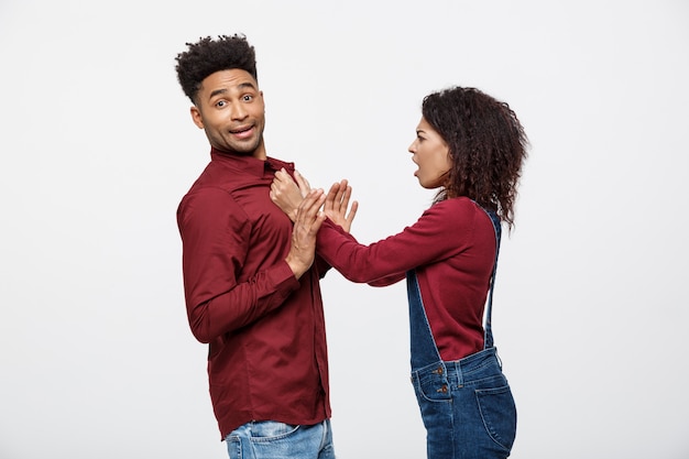 Casal americano africano infeliz em roupas casuais discutindo e figthing.