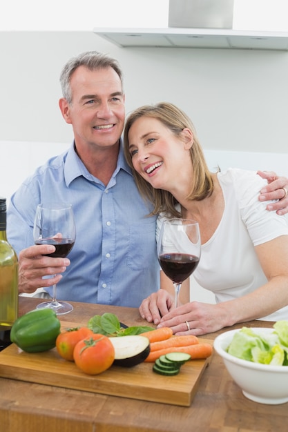 Casal amoroso com copos de vinho na cozinha