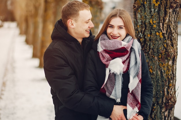 casal amoroso wallking em um parque de neve