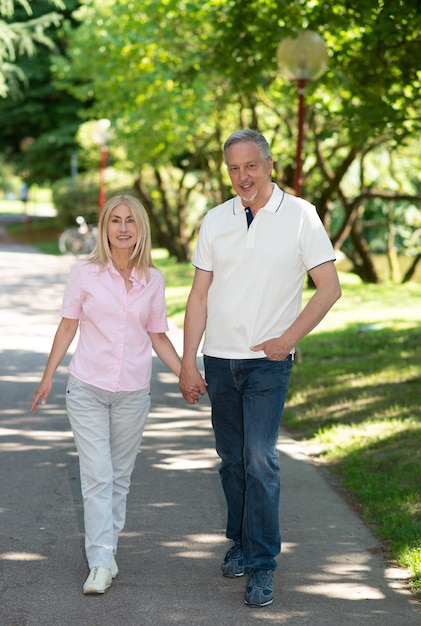 Casal andando em um parque de mãos dadas