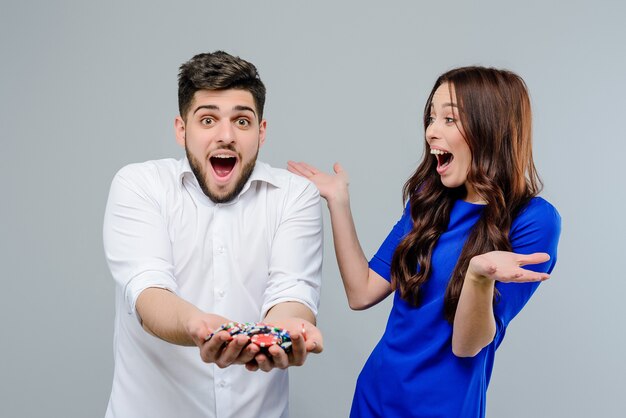 Foto casal animado feliz com fichas de pôquer do cassino