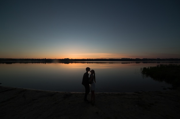 Casal ao nascer do sol na praia