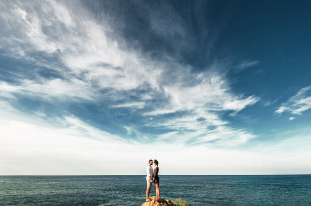 Casal apaixonado à beira-mar. casal feliz à beira-mar. o casal viaja pelo mundo. homem e mulher viajando na ásia. viagem de lua de mel. passeio pelo mar. lindo casal encontra o amanhecer na praia