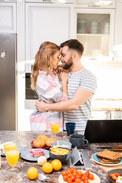 Casal apaixonado, abraçando na cozinha