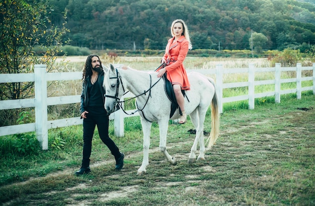 Casal apaixonado andando com cavalo no campo romântico história de amor de casal sensual mulher andando