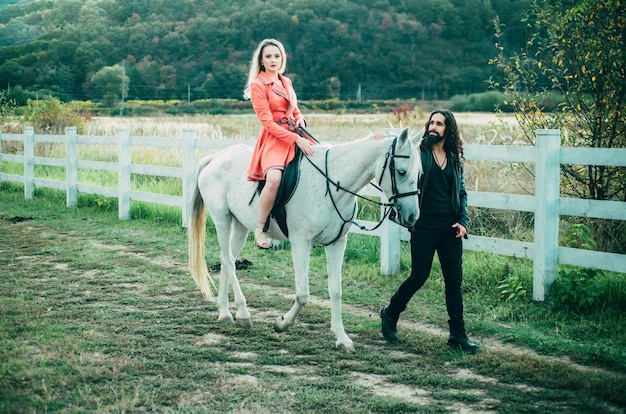 Casal apaixonado andando com cavalo no campo romântico história de amor de casal sensual mulher andando