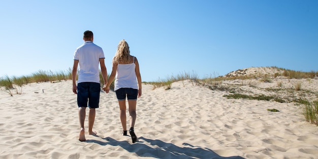 Casal apaixonado andando de volta na praia no panorama de banner de modelo web