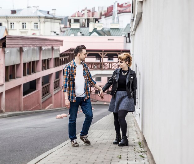 Casal apaixonado andando pela rua de uma cidade moderna