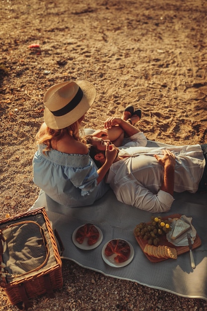 Casal apaixonado aproveitando a hora do piquenique e comida ao ar livre