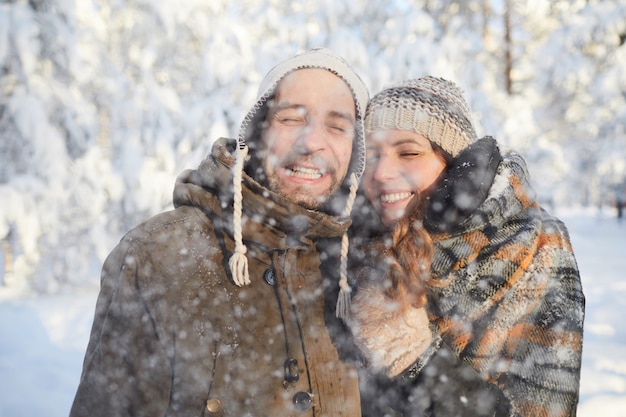 Casal apaixonado, aproveitando a queda de neve