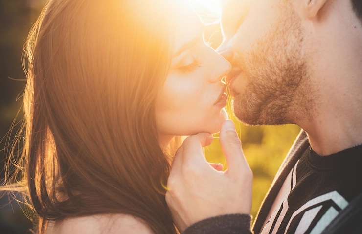 Foto casal apaixonado beijando ao ar livre ao pôr do sol amor e estilo de vida beijo sensual casal jovem beija amantes sensuais