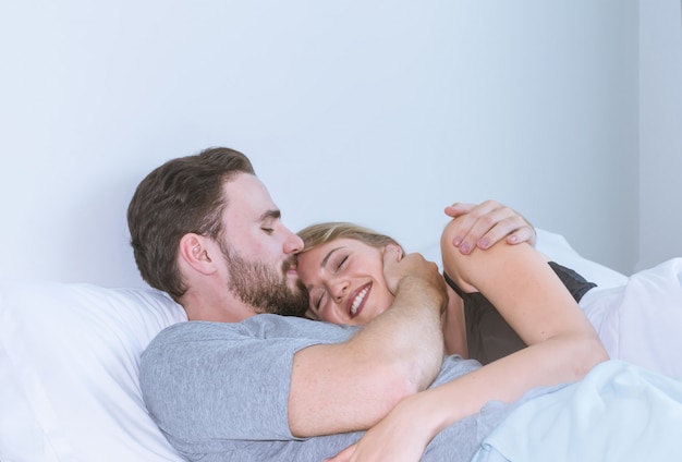 Casal apaixonado beijando na cama. casal feliz juntos deitada na cama.