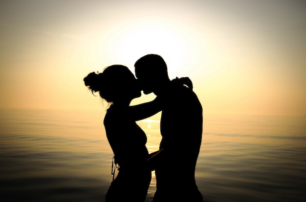 Casal apaixonado beijando no mar - conceito de estilo de vida, emoções e pessoas