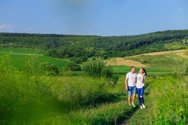 Casal apaixonado caminhando no campo