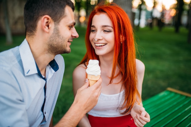 Casal apaixonado com algodão doce no parque de verão