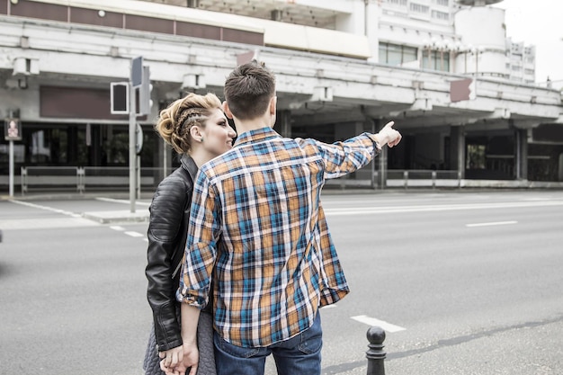 Foto casal apaixonado dançando perto da faixa de pedestres na cidade grande