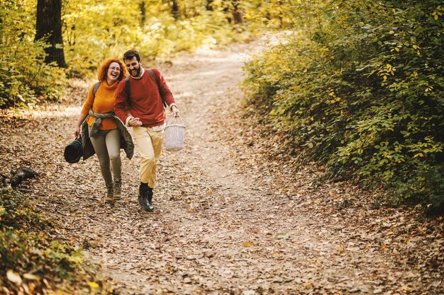 Casal apaixonado, de mãos dadas e caminhando na natureza em um lindo dia de outono.