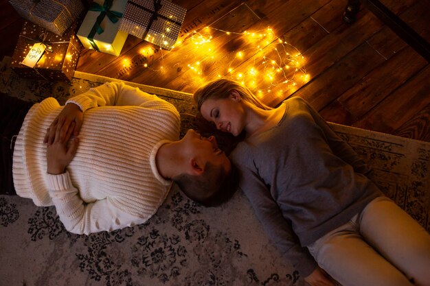 Foto casal apaixonado, deitado no chão em casa