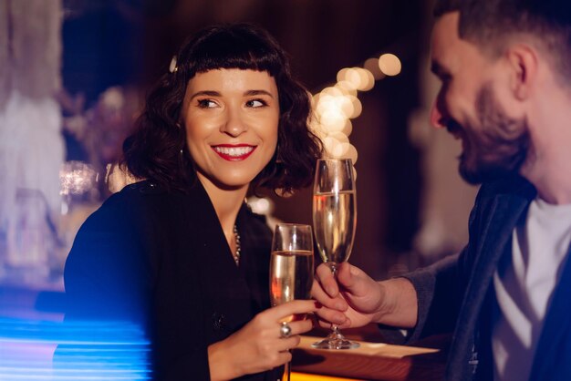 Casal apaixonado e feliz curtindo um drinque juntos no bar. Celebração de festa Noite romântica