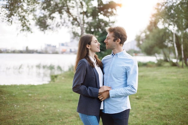 Casal apaixonado em pé na margem do lago