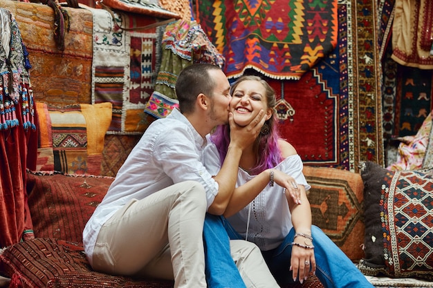 Casal apaixonado escolhe um tapete turco no mercado.