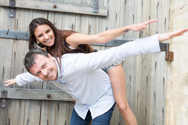 Casal apaixonado - homem caucasiano tendo sua mulher nas costas