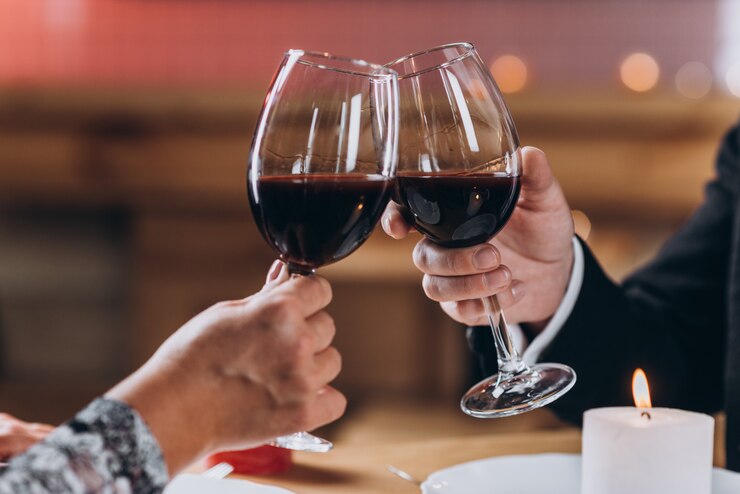 Casal apaixonado levanta copos de vinho tinto