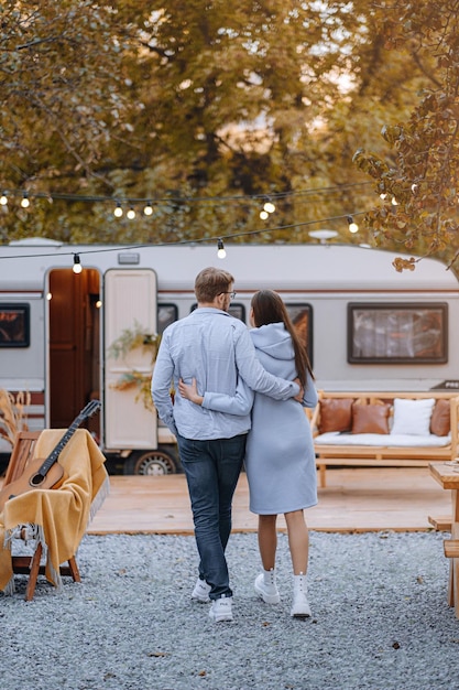 Casal apaixonado morando em trailer no camping e se divertindo e feliz